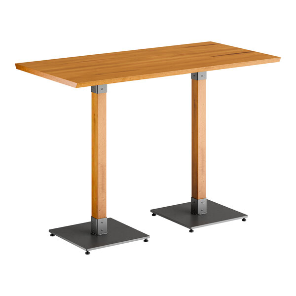 A Lancaster Table & Seating bar height table with a wooden live edge top and two metal legs.