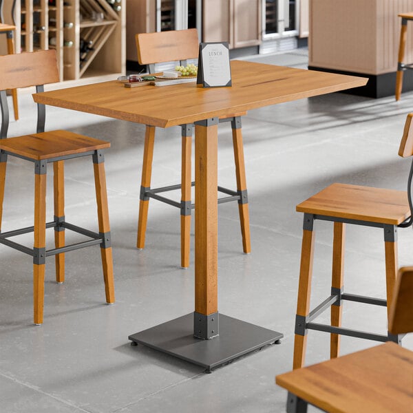 A Lancaster Table & Seating live edge wood table with wooden stools.