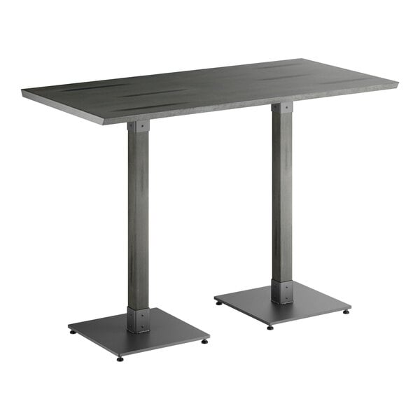 A rectangular bar-height table with a solid wood top and two metal pedestal legs, all in a slate gray finish.