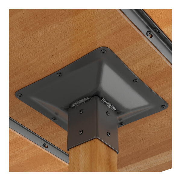 A metal corner bracket on a Lancaster Table & Seating wood table.