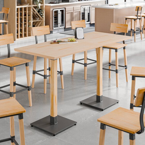A Lancaster Table & Seating live edge wood bar height table with chairs.