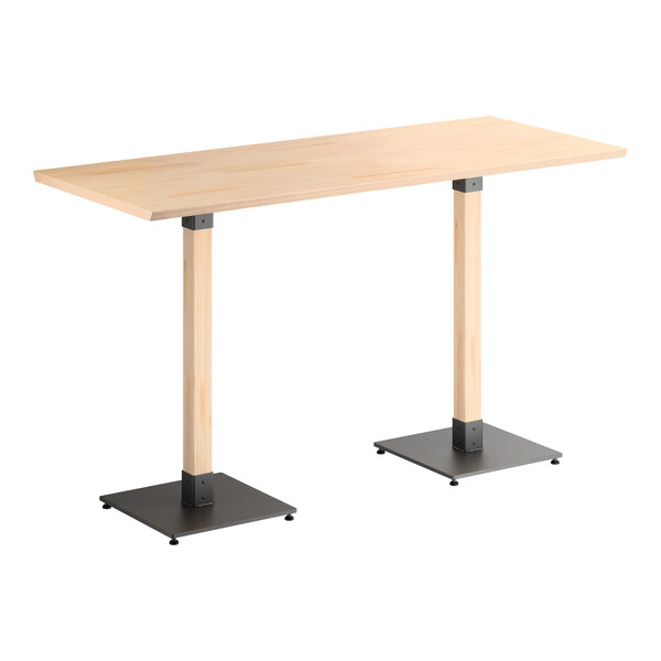 A rectangular bar-height table with a light wood top and two square metal bases supporting wooden legs.