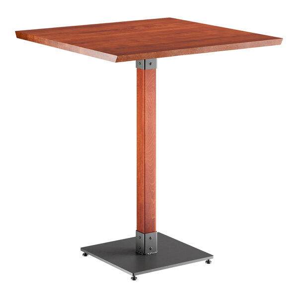 A Lancaster Table & Seating bar height table with a square wooden top and metal base.