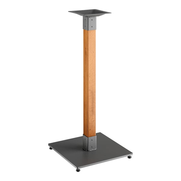 A metal and wood Lancaster Table & Seating bar height table base with a honey maple finish.