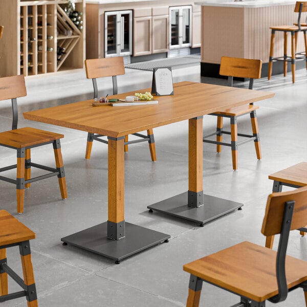 A Lancaster Table & Seating wooden table with a honey maple finish and wooden chairs.