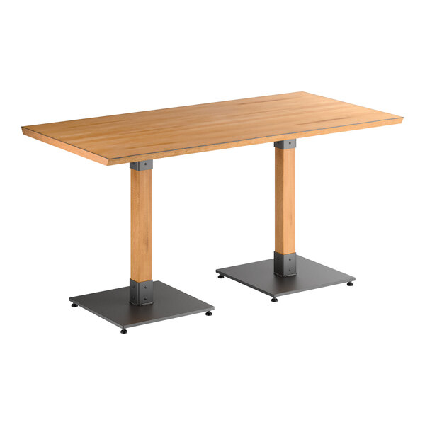 A rectangular table with a honey-colored wooden top and two square metal bases.
