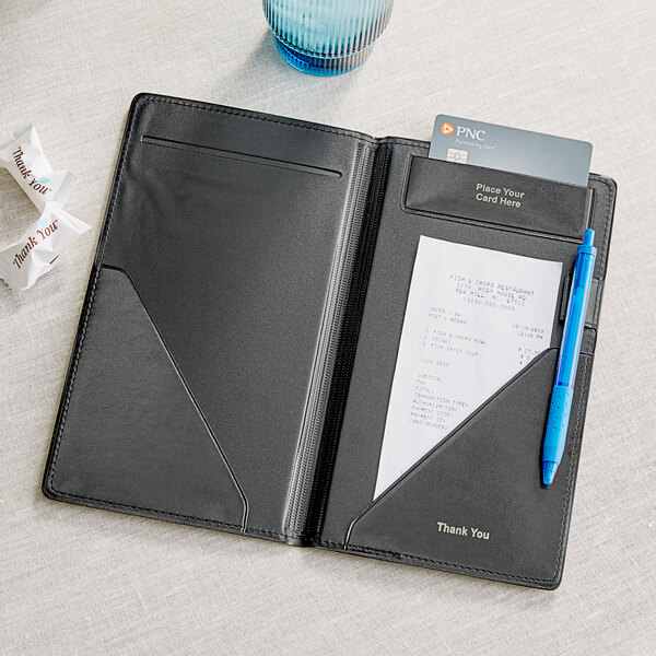 A brown vinyl Tablecraft server book with a pen and a piece of paper.