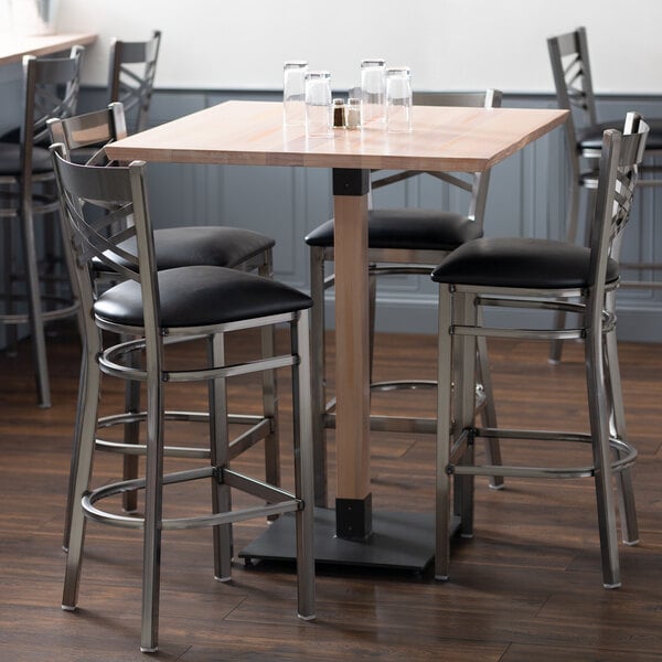 A Lancaster Table & Seating bar height table with chairs around it.