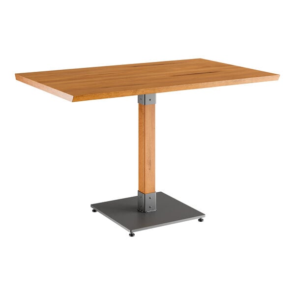 A Lancaster Table & Seating wooden table with a live edge and a metal base.