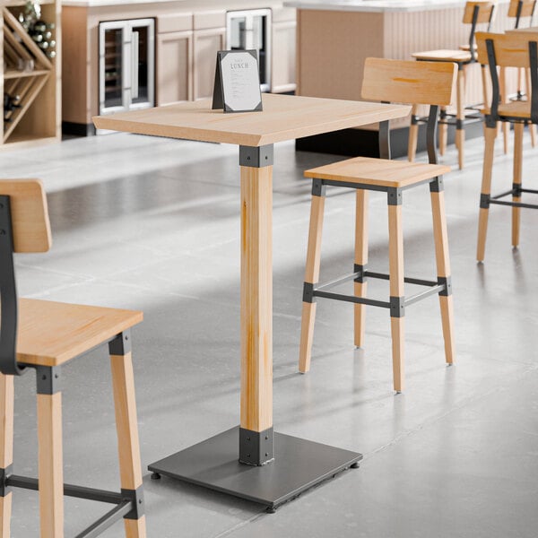 A Lancaster Table & Seating live edge bar height table with a bleached oak finish and two stools.
