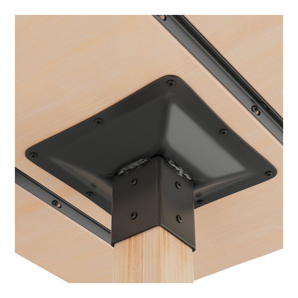 A close-up view of the underside of a solid wood bar height table with a bleached oak finish and black metal support brackets.