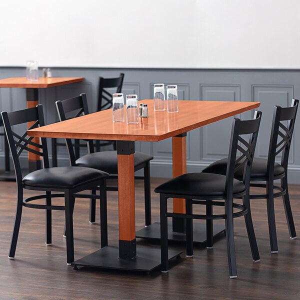 A Lancaster Table & Seating Industrial live edge wood table with black chairs and glasses on it.