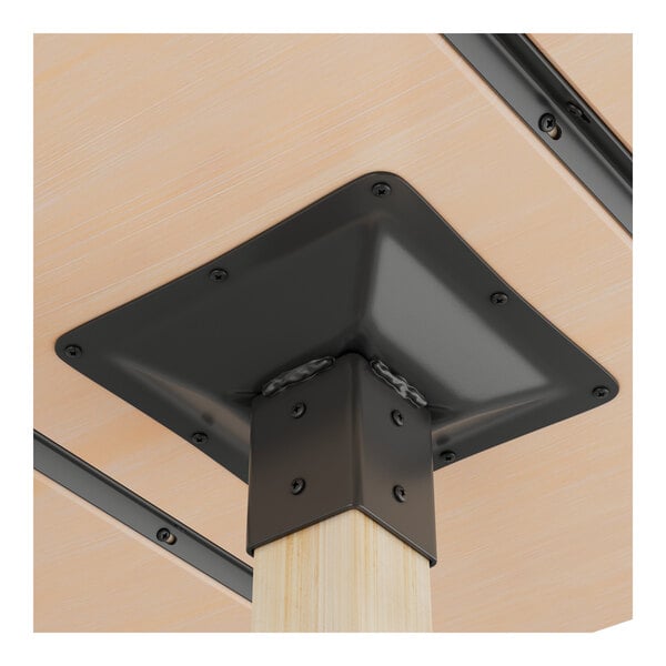 A metal table base with a bleached oak finish leg attached to the underside of a wooden tabletop.