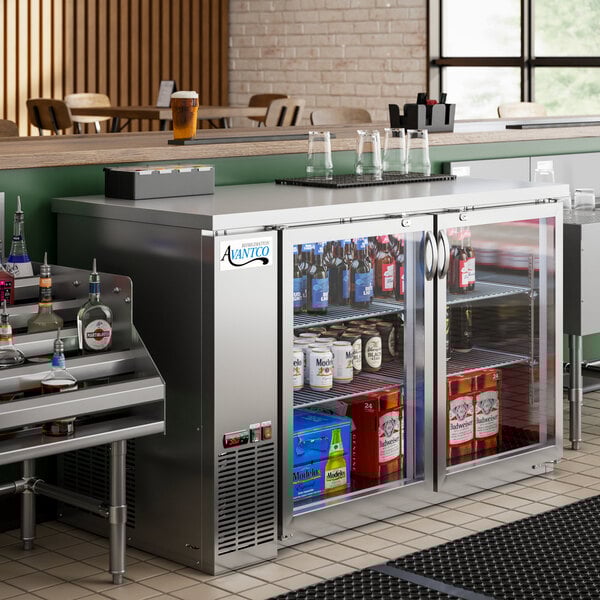 An Avantco back bar refrigerator with bottles on metal shelves.