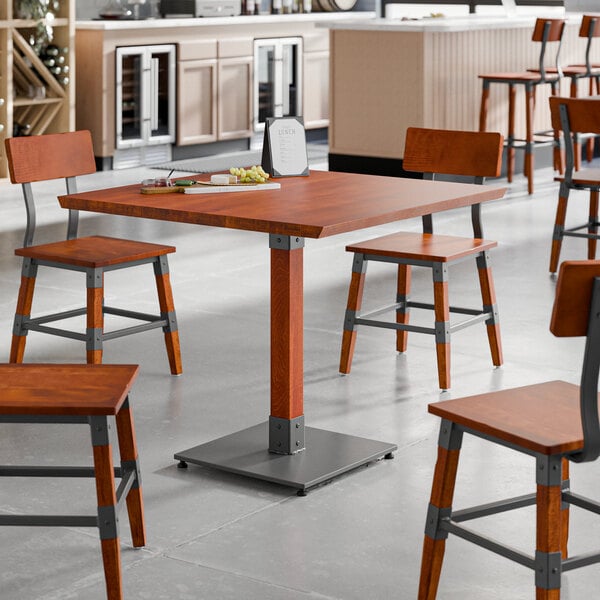 A Lancaster Table & Seating wooden table with metal legs.