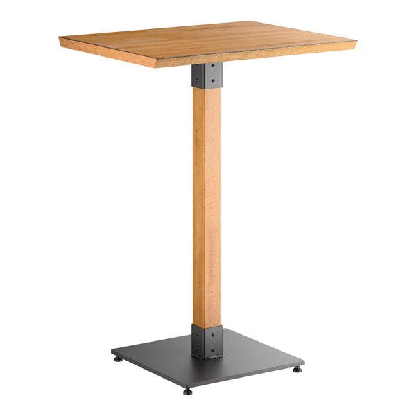 A rectangular bar-height table with a honey maple wood top and a single wooden pedestal supported by a square metal base.