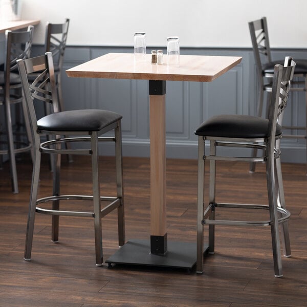 A Lancaster Table & Seating live edge wood bar table with an antique white wash finish.