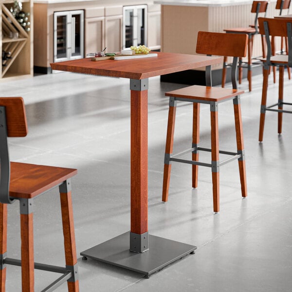 A Lancaster Table & Seating live edge wood bar height table with stools.