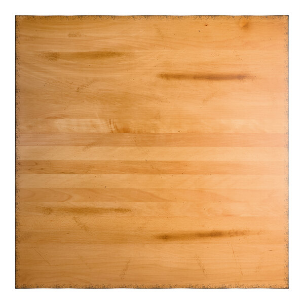 A square wooden surface with a honey maple finish, featuring visible wood grain and some darker marks.