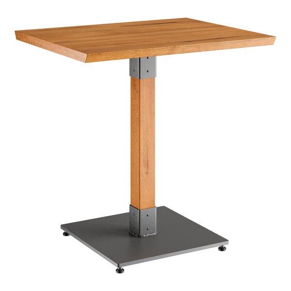 A Lancaster Table & Seating wooden table with a metal base.