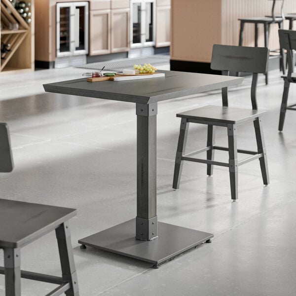 A Lancaster Table & Seating solid wood live edge table with chairs and a tray of food on it.