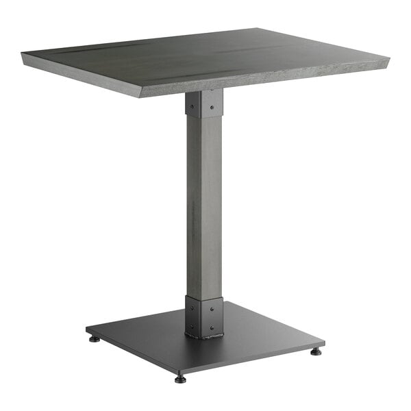 A rectangular table with a solid wood top, a central metal pedestal, and a square metal base, all in a slate gray finish.