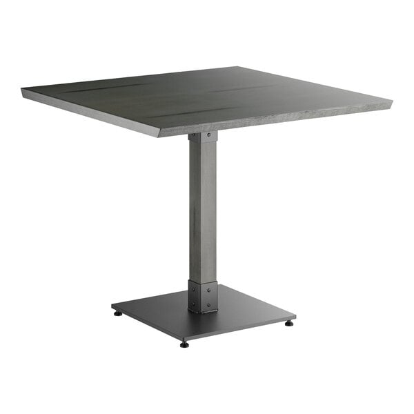 A square table with a solid wood top, a single central metal support, and a square metal base, all in a slate gray finish.