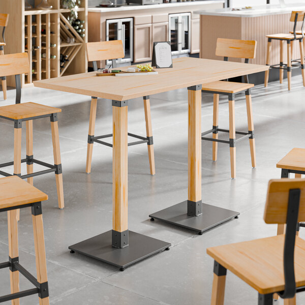 A Lancaster Table & Seating live edge table with wooden legs.
