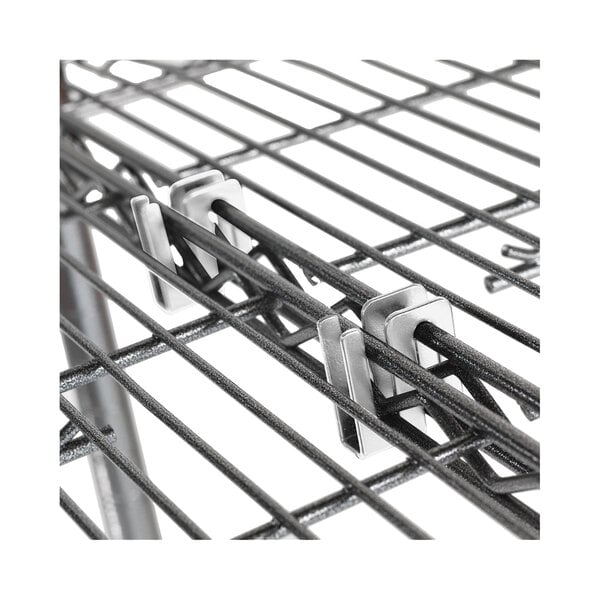A close-up of a metal rod with two silver S hooks on it.