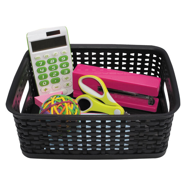 A black basket with a calculator and office supplies including a pair of yellow scissors.