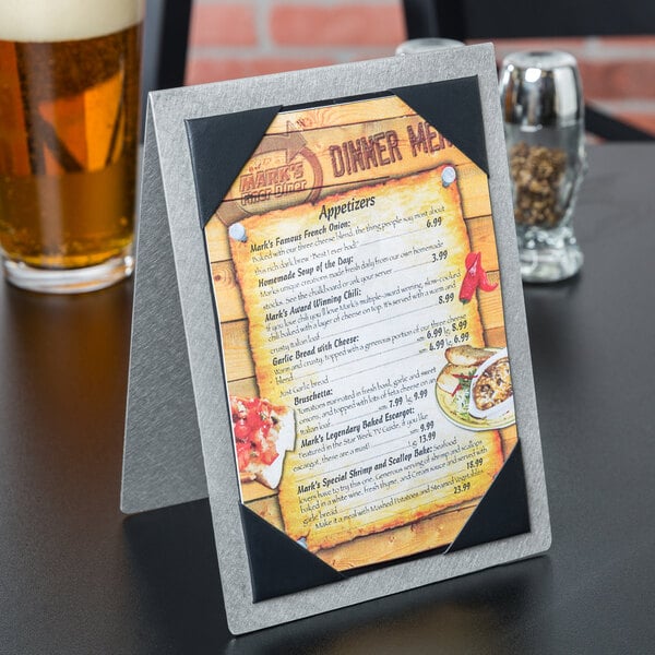 A Menu Solutions Alumitique table tent on a table with a menu.
