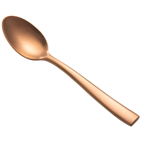 A close-up of a Bon Chef matte rose gold soup/dessert spoon with a handle.