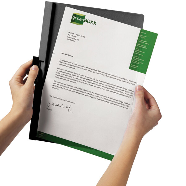 A person holding a Durable clear and graphite report cover with a document inside.