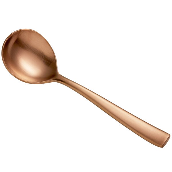 A close-up of a Bon Chef matte rose gold stainless steel bouillon spoon with a copper finish.