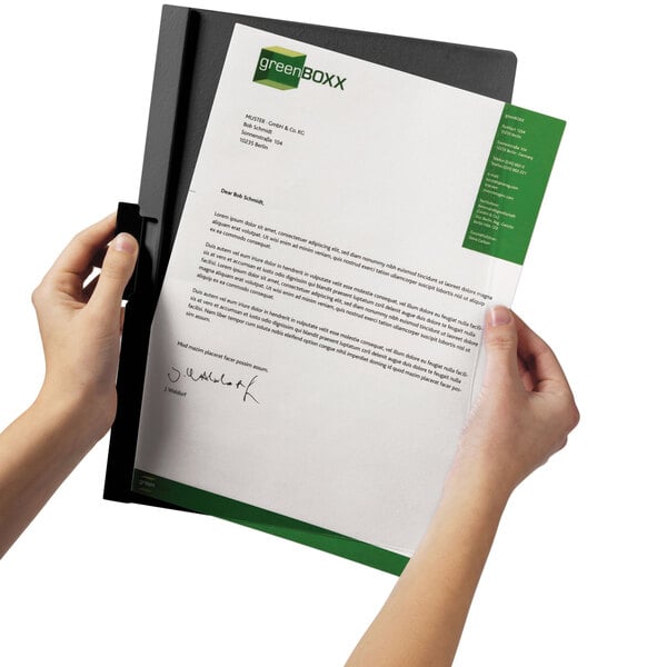 A person holding a Durable black and clear report cover with a document inside.