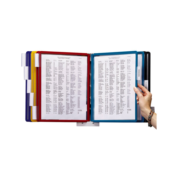 A hand using a Durable SHERPA wall-mount reference system to hold white papers.