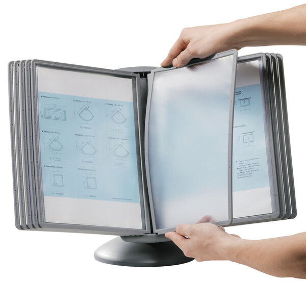 A person holding a Durable Sherpa gray borders letter sized 10 panel motion desktop reference system folder.