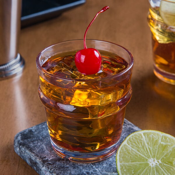 A Libbey Tritan plastic rocks glass with ice and a cherry on top.