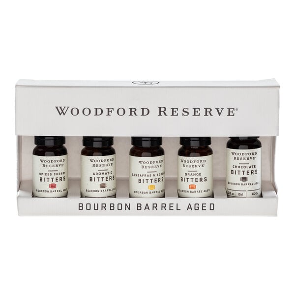 A boxed set containing five small bottles of Woodford Reserve bourbon barrel aged bitters in different flavors.