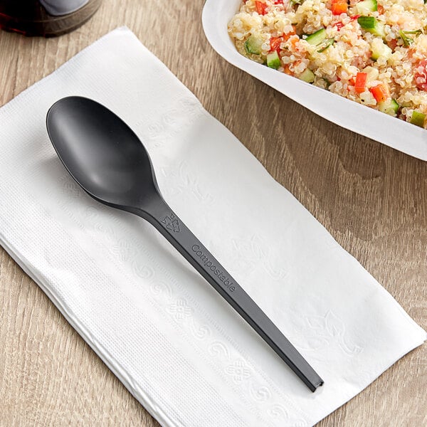 A white bowl of food with a black EcoChoice CPLA plastic spoon in it.