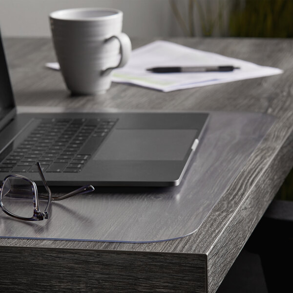 A laptop on an ES Robbins desk with a pen and glasses.