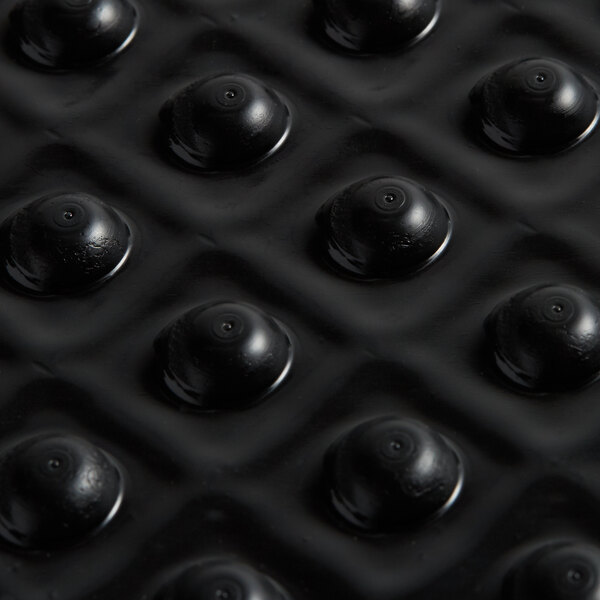 A close up of a black ES Robbins anti-fatigue floor mat with a circle pattern in the center.
