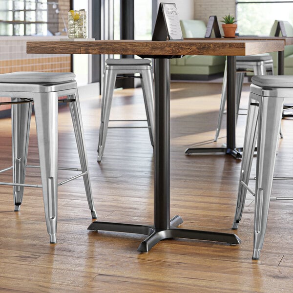 A Lancaster Table & Seating black cast iron counter height table base in a restaurant dining area.