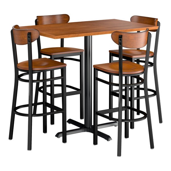 A rectangular rustic walnut bar height table with four matching boomerang bar stools featuring black metal frames and wooden seats and backs.