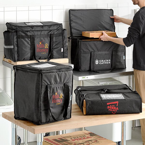 A man using a black Choice insulated food delivery bag to carry pizza boxes.