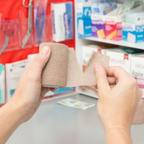 a hand holding a roll of medical tape