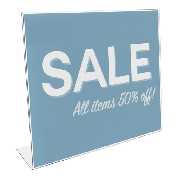 A clear, slanted sign holder displaying a blue sign with the text 'SALE All items 50% off!' in white letters.
