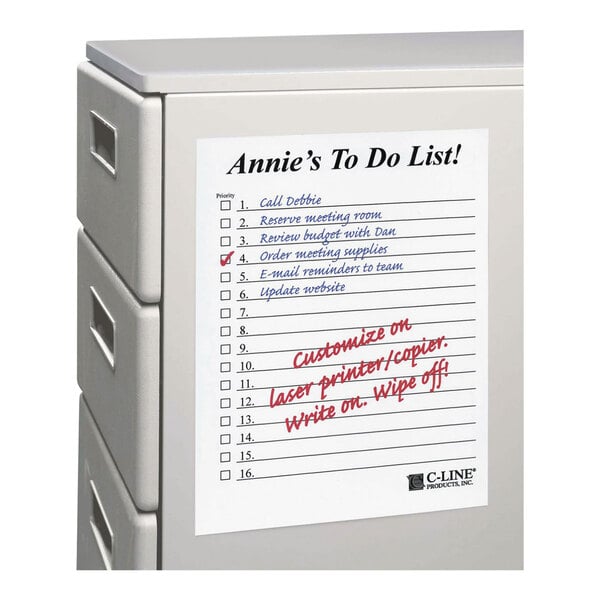 A white dry erase sheet with a printed to-do list is attached to the side of a gray filing cabinet.