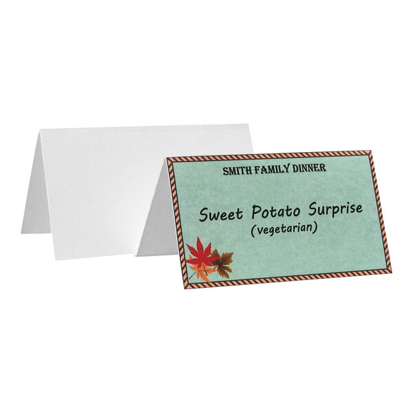 A folded tent card with a decorative border, autumn leaves, and text indicating a vegetarian dish for a family dinner.
