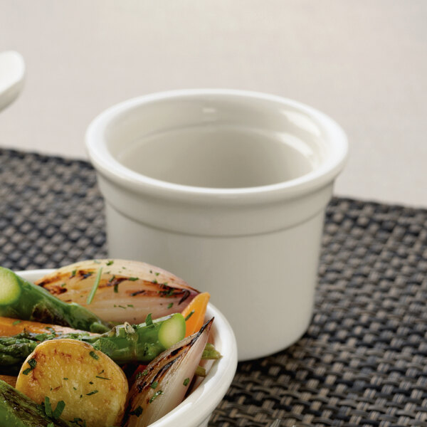 A Libbey white porcelain custard dish filled with food on a table.